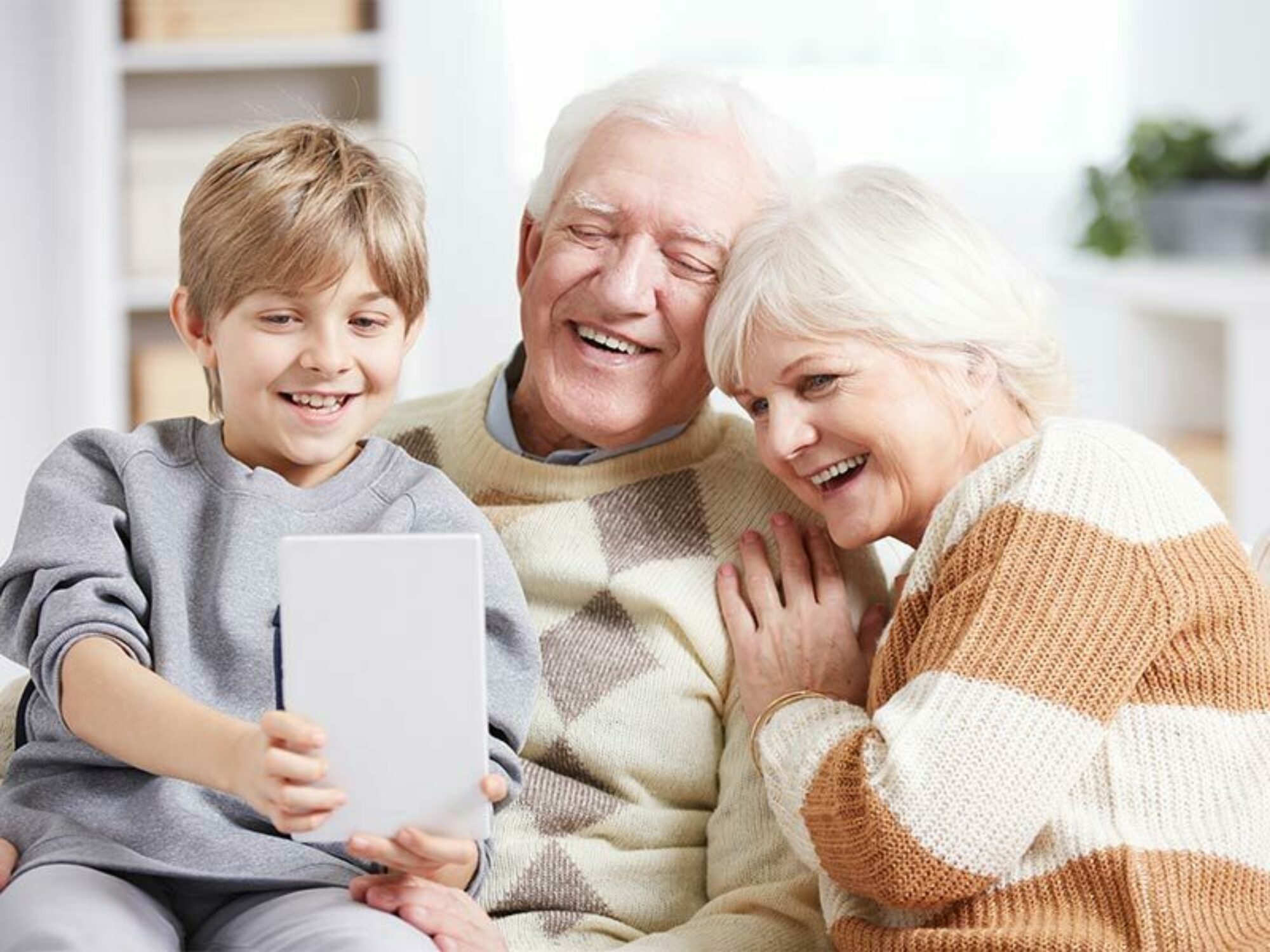Grandparents with their grandson looking at a tablet