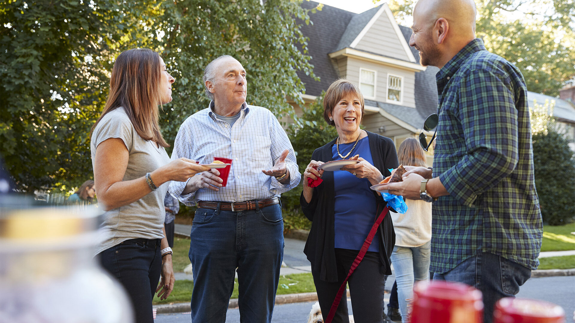 four people talking in a driveway