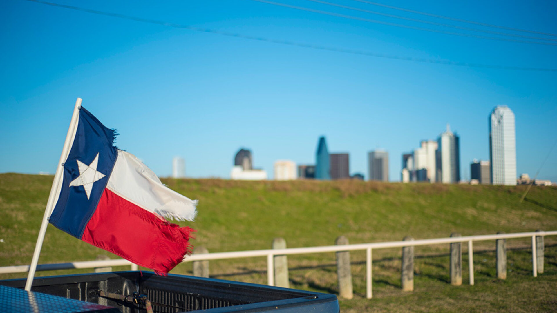 Texas flag with Dallas skyline in the background
