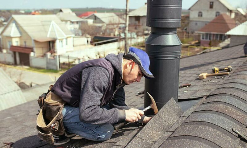 Man fixing shingles on a roof