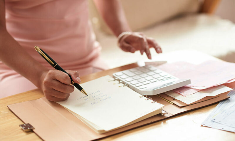 Woman going over finances and budgets with calculator.