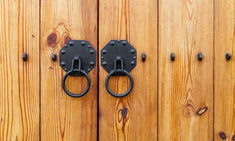 Wooden double door with cast iron pull handles.