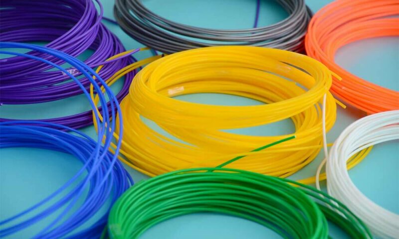 Multiple colorful rolls of 3D-printing filaments.