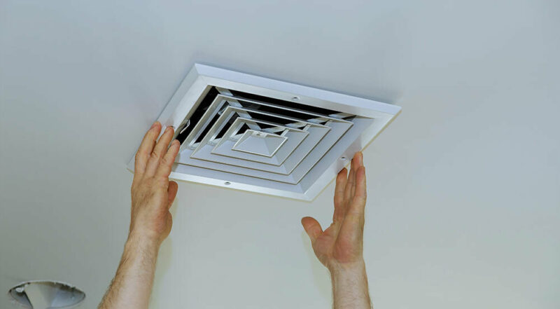 man opening his home air vents