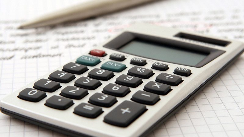 Calculator with pen for calculating PITI (principal, interest, taxes, and insurance) in a mortgage payment.