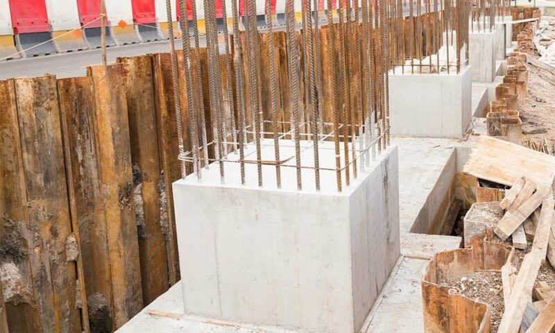 Concrete pillars being poured with rebar.