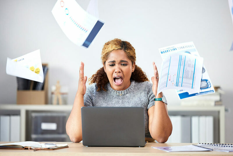 woman throwing documents and screaming at computer