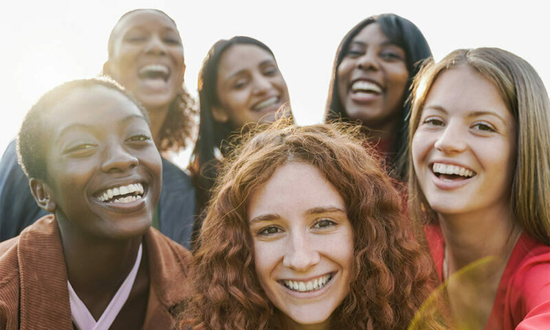 A diverse group of girls smiling at the camera.