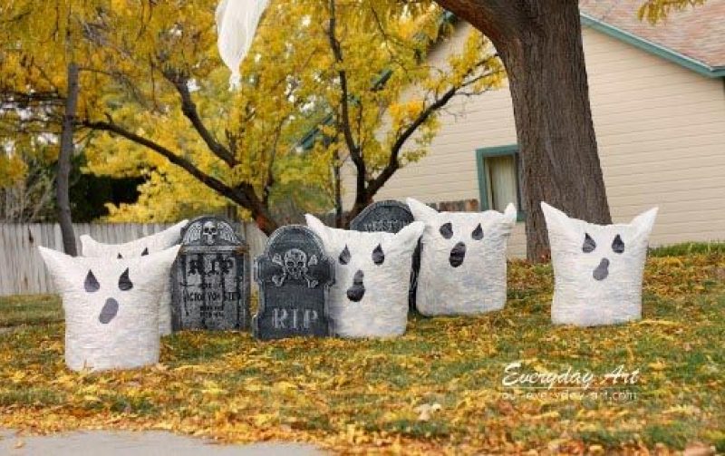 bags of leaves with ghost faces painted on the outside