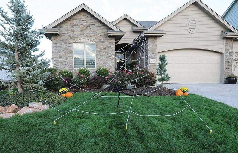 home with spiderweb decorations in yard