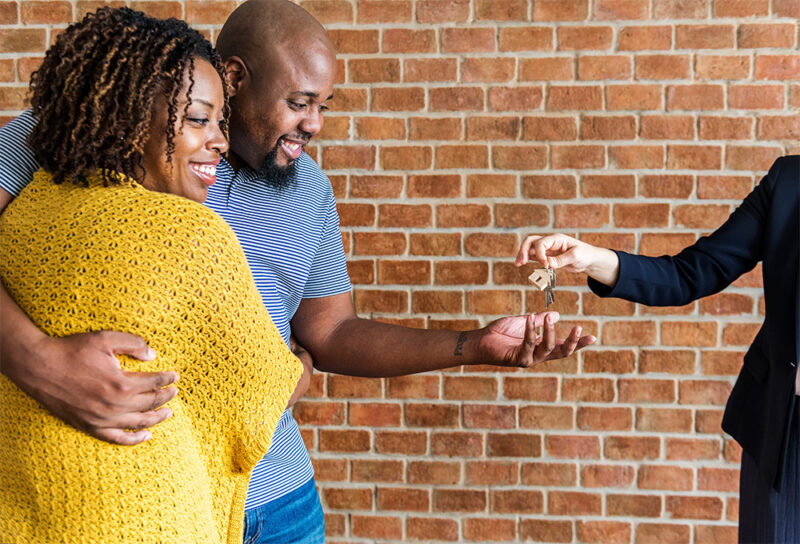 homebuyers getting the keys to their home from a realtor