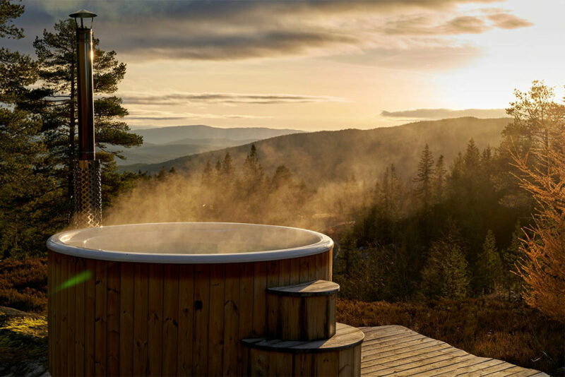 hot tub on a deck overlooking mountainous sunset