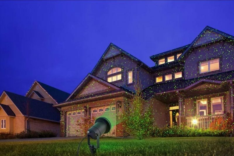 house at night with green lighting in yard