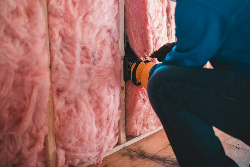 insulation being added to walls of a new home construction