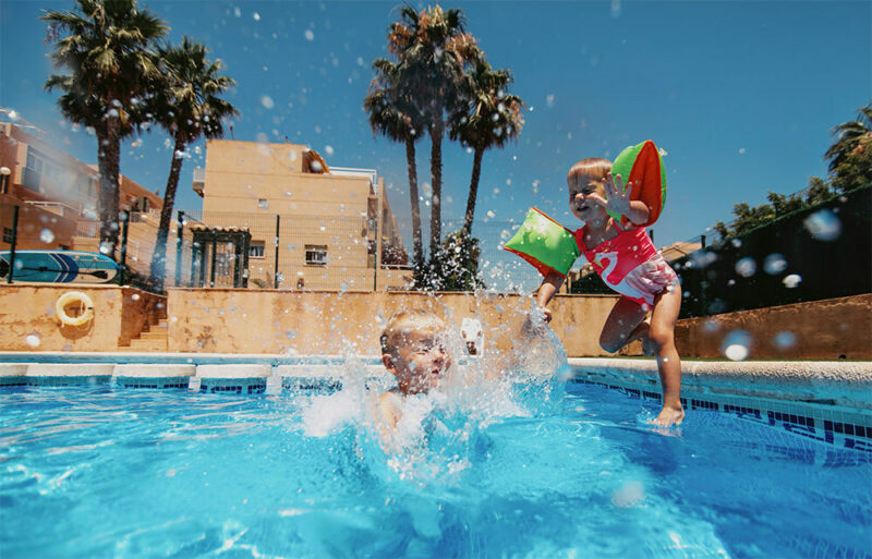 kids with floaties on jumping into a pool