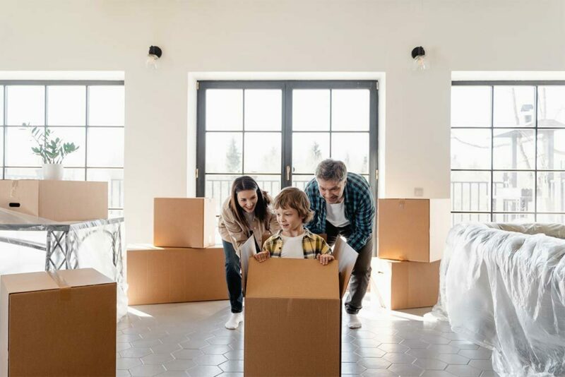 Young boy in a moving box with his parents