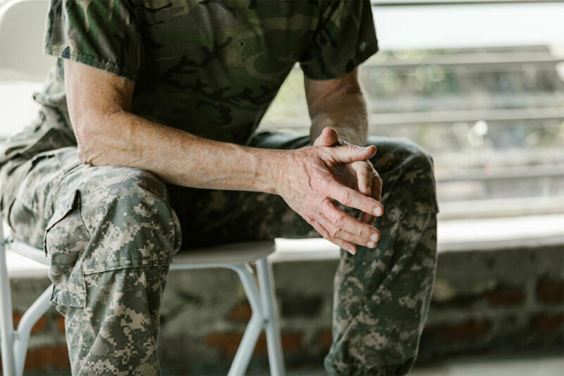 Soldier wearing camo sitting on a bench