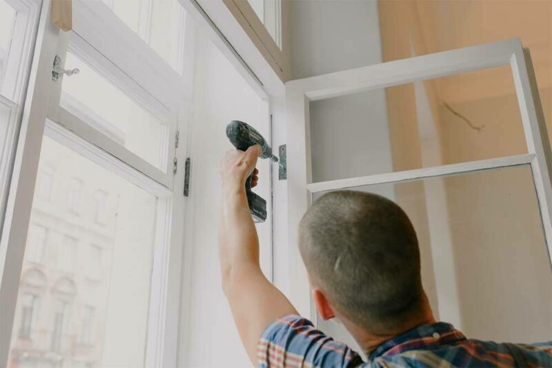 man using drill on a door