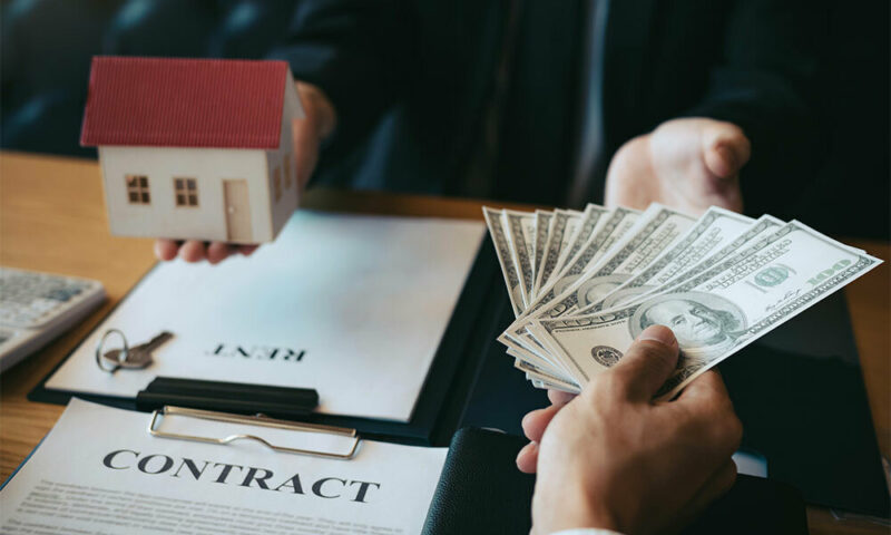 woman holding a model house in exchange for money