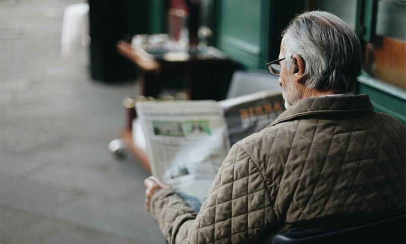 old man reading newspaper