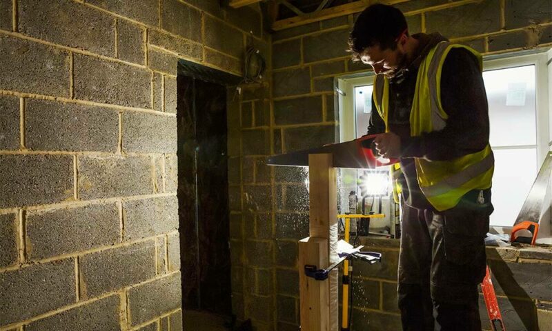 Man laying bricks in new home construction.