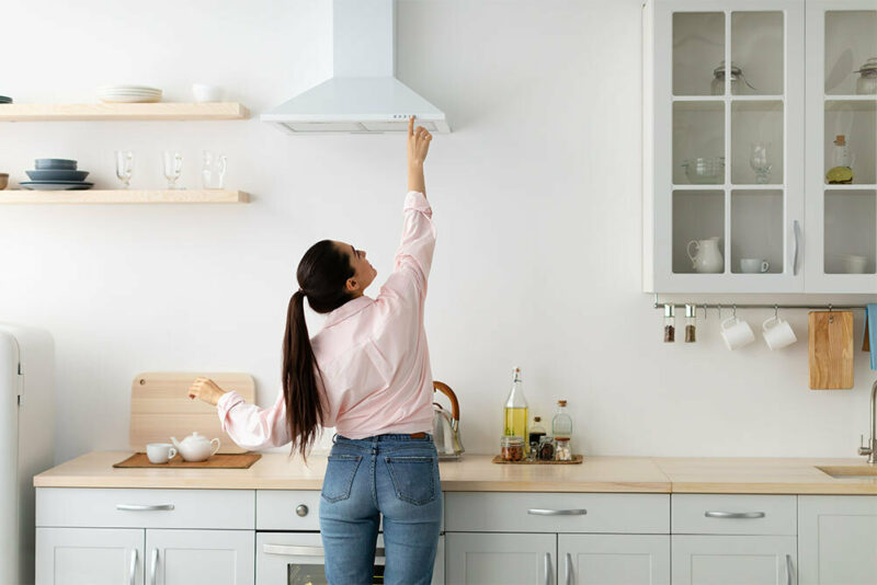 woman adjusting range hood