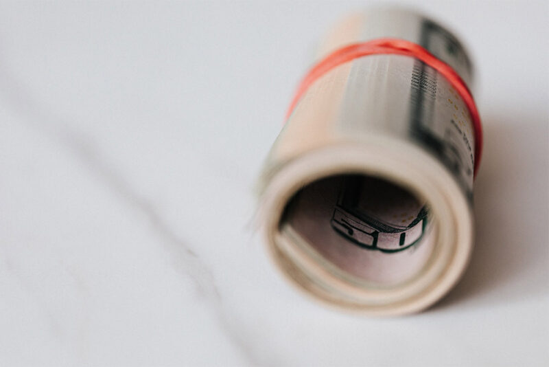 stack of cash rolled up with a rubber band