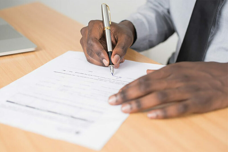 man signing legal documents