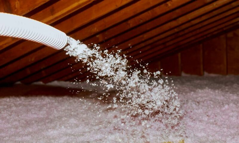 Spraying insulation foam into an attic.