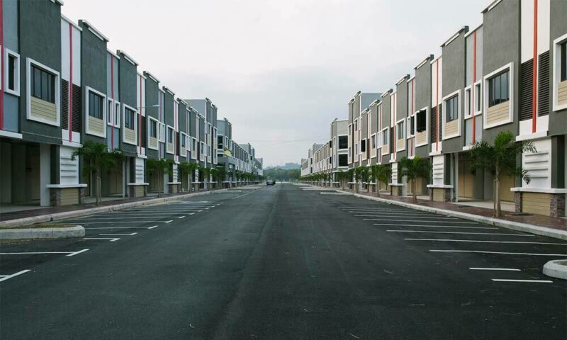 Street running through apartment complex on cloudy day.