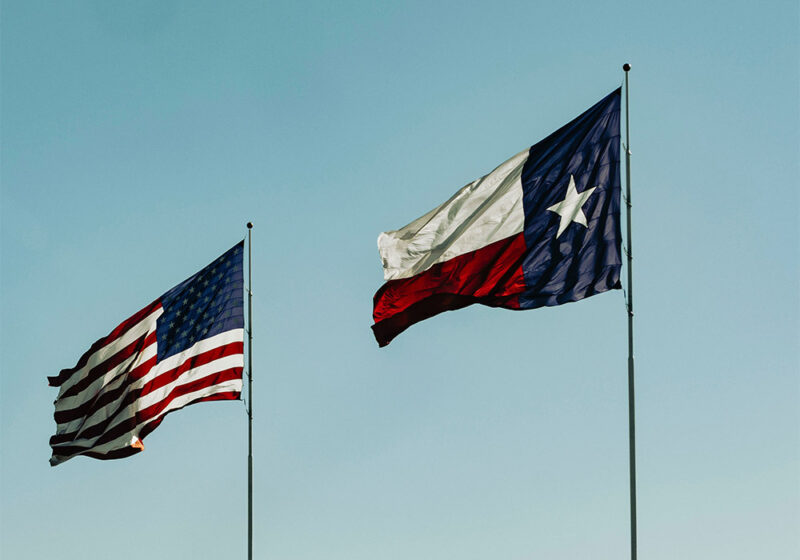 United States and Texas flags blowing in the breeze