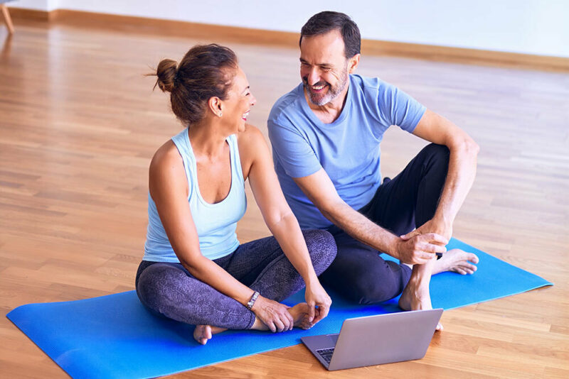 Two people sitting on a yoga mat