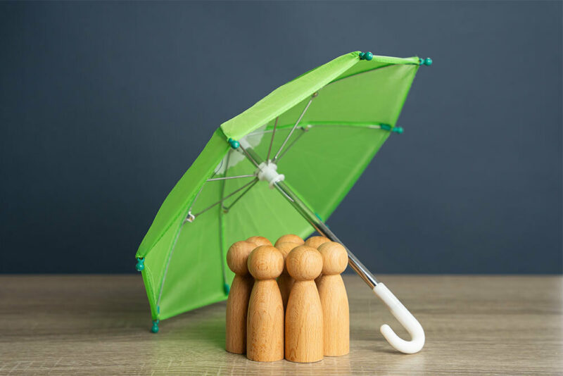 wooden family under a green umbrella