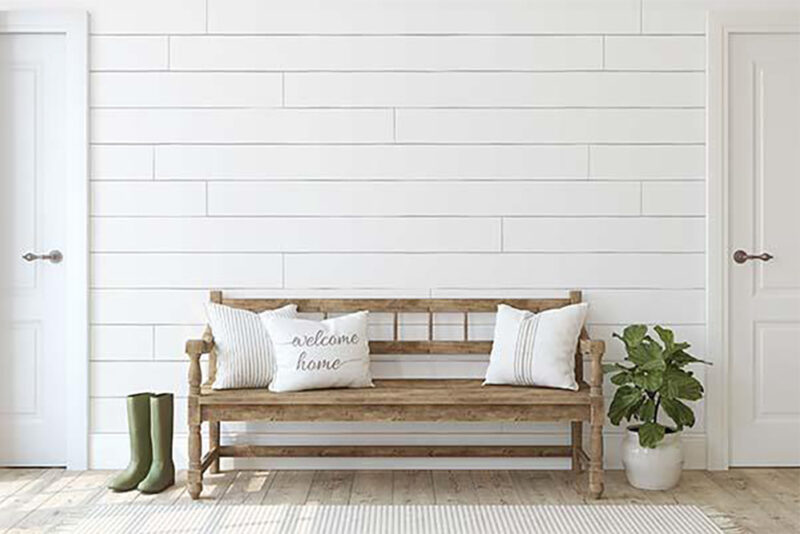 White Shiplap with decorative bench, pillows, and a plant