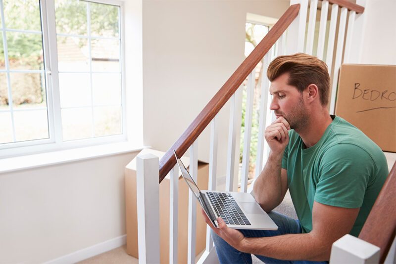 Young man looking over finances in his new home